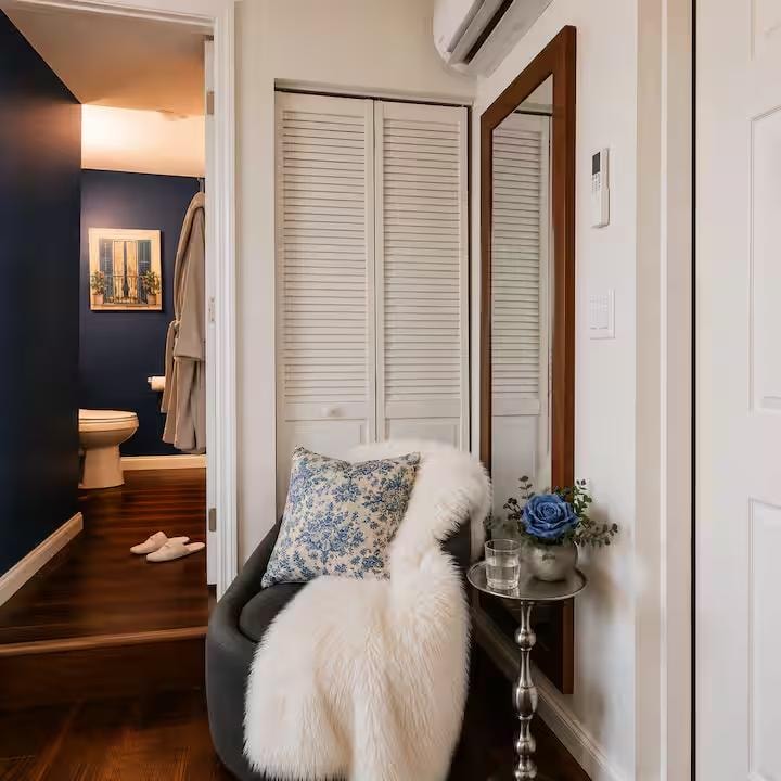 Open closet with wooden shelving, hangers, in-room safe and air purifier